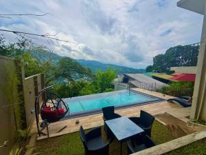 a swimming pool with a table and chairs next to it at Boutique Dinu in Kandy