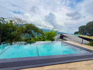 a large swimming pool with blue water at Boutique Dinu in Kandy