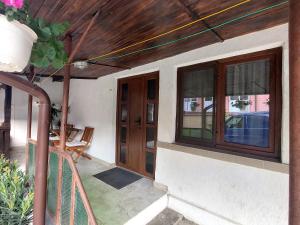 a porch of a house with a door and windows at Casa Anomis in Călimăneşti