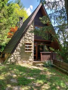 a small stone house with a gambrel roof at Chata Huslenky in Huslenky