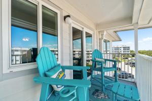 two blue rocking chairs on a porch with a view at Hotel condo features beach access shared pool - near town in Fort Morgan