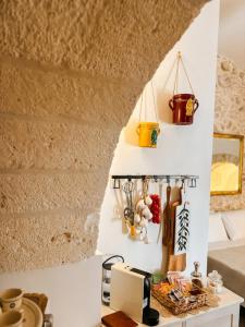 a kitchen with a counter and a wall with utensils at La Suite di Alizeh in Ostuni