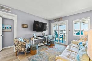 a living room with a couch and a flat screen tv at Hotel condo features beach access shared pool - near town in Fort Morgan