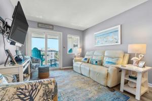 a living room with a couch and a tv at Hotel condo features beach access shared pool - near town in Fort Morgan