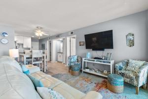 a living room with a white couch and a flat screen tv at Hotel condo features beach access shared pool - near town in Fort Morgan +53 photos