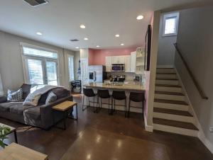 a living room with a couch and a kitchen at 2-Bedroom Condo Unit with Free Parking & 2 King Beds in Nashville