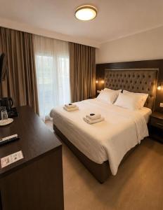 a hotel room with a large bed and a desk at Hotel Avra in Perea