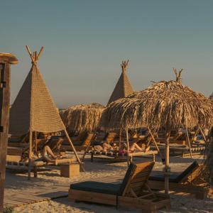 a group of people laying on a beach with straw umbrellas at INFINITY Sea View Luxury SUITE in Mamaia Sat/Năvodari
