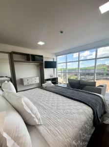 a bedroom with a large bed with a large window at Hotel Pasqualotto in Chopinzinho +36 photos