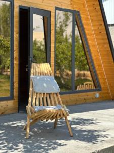a wooden chair sitting in front of a building at House Saadat in Tossor