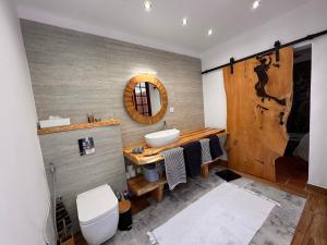 a bathroom with a sink and a wooden wall at Casa das Flores Funchal in Funchal