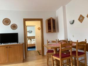 a dining room with a table and a television at Haus Hoher Sattel in Leutasch