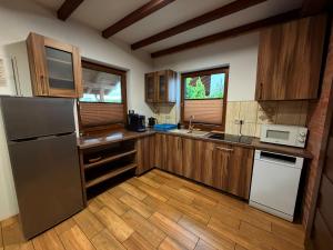 a kitchen with wooden cabinets and a stainless steel refrigerator at Mazurskie El Dorado in Mikołajki