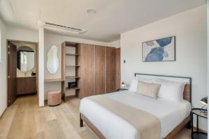 a bedroom with a large white bed and a mirror at Nido x Downtown MTY in Monterrey +66 photos