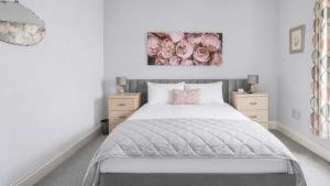 a bedroom with a large bed with two night stands at Modern Apartment with Garden in Rothesay