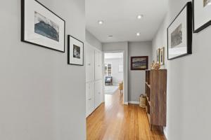 a hallway of a home with white walls and wood floors at The Eastman House in Santa Cruz