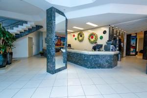 a man standing at a counter in a store lobby at Hotel Ilha da Madeira in Balneário Camboriú