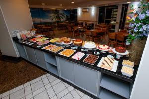 a bakery counter with many different cakes and pastries at Hotel Ilha da Madeira in Balneário Camboriú