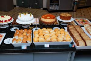 a buffet of cakes and other cakes and pastries at Hotel Ilha da Madeira in Balneário Camboriú +2 photos