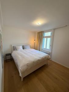 a bedroom with a white bed and a window at Haus Enisa in Horgen