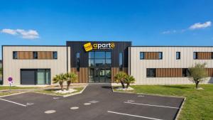 a building with a parking lot in front of it at APARTÉ HOTEL Dijon Sud in Chenôve +13 photos