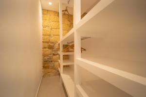 a staircase in a house with a stone wall at DaiRa 103 Luxury Suite sulle Mura di Cefalù in Cefalù