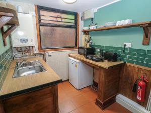 a small kitchen with a sink and a counter at Cabin No 5 - Salt and Fern Cabins in Port Talbot