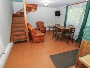 a living room with a table and chairs and a staircase at Cabin No 5 - Salt and Fern Cabins in Port Talbot