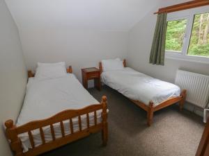 two twin beds in a room with a window at Cabin No 5 - Salt and Fern Cabins in Port Talbot