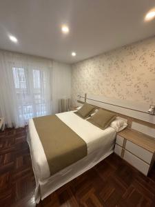 a bedroom with a large bed and a wooden floor at Hostal San Fernando in Santander