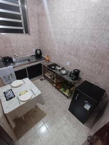 a small kitchen with a table and a sink at Apt Petrópolis - Imperial in Petrópolis +3 photos