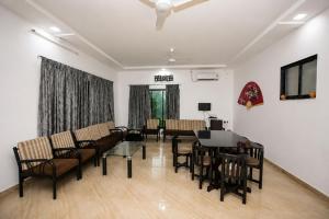 a living room with a couch and a table and chairs at Attra Farms in Karjat