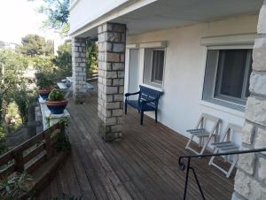 a deck with a blue chair and chairs on a house at Appartement Fort Lamalgue in Toulon
