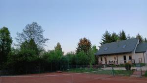 a tennis court in front of a house at Słoneczny Set in Wólka Klucka