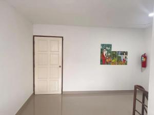 a white room with a door and a picture on a wall at Welcome Suites in Pattaya South