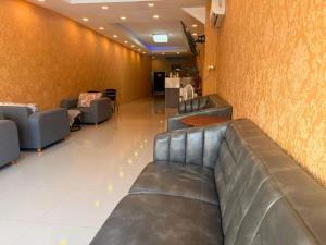 a waiting room with leather couches in a waiting room at Welcome Suites in Pattaya South