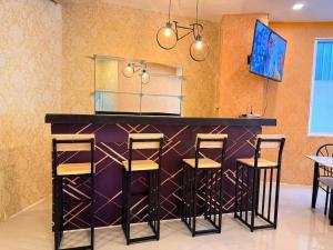 a bar in a restaurant with three stools at Welcome Suites in Pattaya South