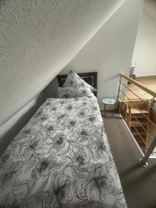a bedroom with a bed with a floral bedspread at Grenz-Apartment an der Aach in Rielasingen-Worblingen