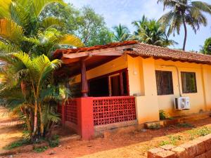 a house with a red fence in front of it at Mangrove Village Inn in Kāsarkod