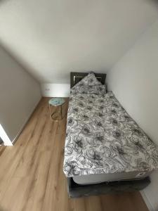a bed in a small room with a wooden floor at Grenz-Apartment an der Aach in Rielasingen-Worblingen +3 photos