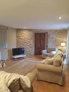 a living room with two couches and a tv at L'Era de Can Ribes Tor in Tor