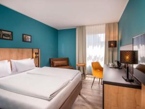 ein Hotelzimmer mit einem Bett und einem Stuhl in der Unterkunft Mercure Hotel München Neuperlach Süd in München
