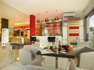 a restaurant with a table and chairs and a bar at Ibis Brive Centre in Brive-la-Gaillarde