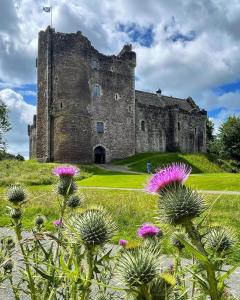 an old castle with flowers in front of it at Comrie Old Schoolhouse in Comrie