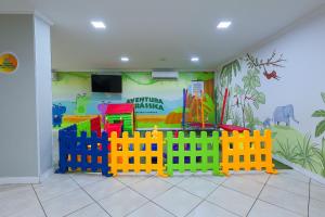 Ein Kinderzimmer mit einem Spielzeugzaun vor einer Wand in der Unterkunft Hotel Açores in Balneário Camboriú