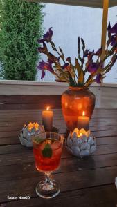 a table with two candles and a potted plant at Dacha Pool and Grill in Karavan