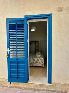 a blue door leading into a bedroom with a bed at Cabina Da Mare in Marettimo