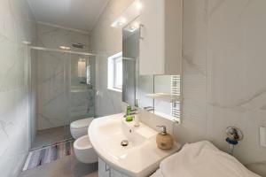 a white bathroom with a sink and a shower at Villa Lucia in Mokošica +39 photos