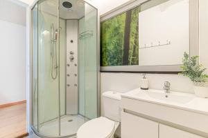 a bathroom with a shower and a toilet and a sink at Host In Olivença in Vila Nova de Famalicão +42 photos