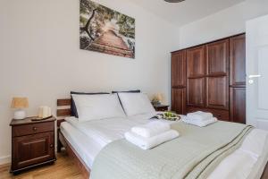 a bedroom with a bed with two towels on it at Zegrze Lake Apartament VIRIDIAN z widokiem na jezioro, tarasem i parkingiem in Zegrze